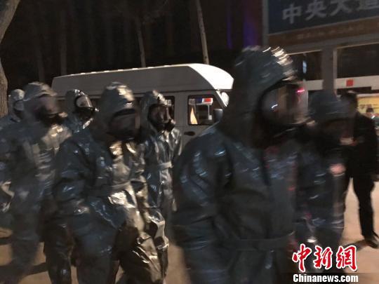 十几名身着防护服的人员头戴面具进入事发地。　胡健 摄